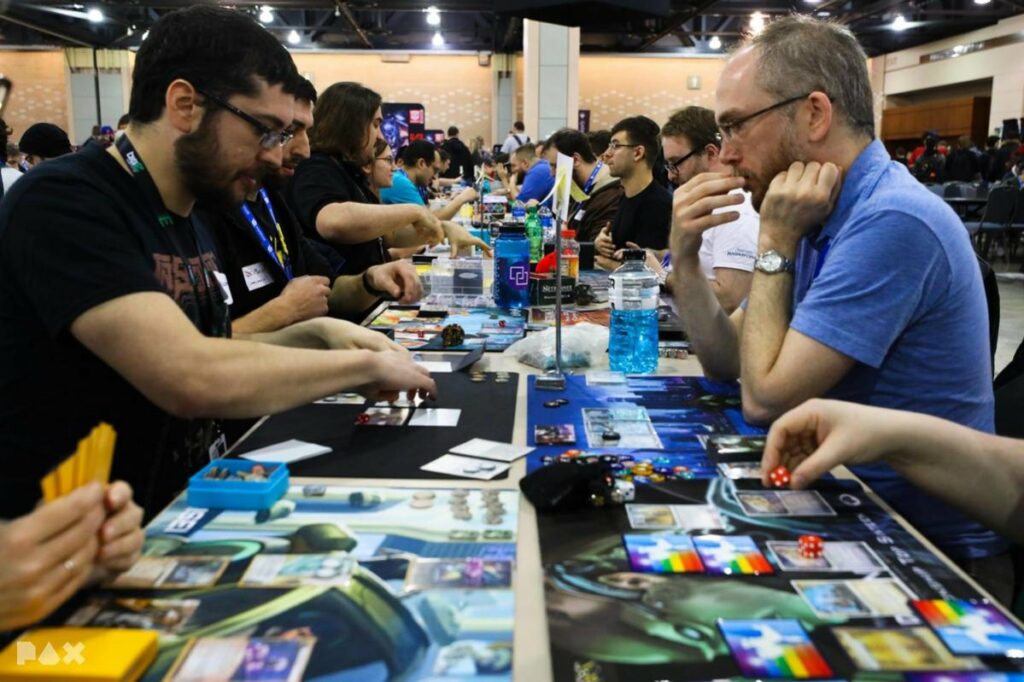 People playing Netrunner at a long table