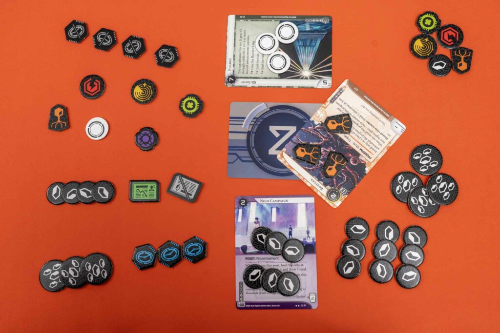 Official NSG Netrunner tokens laid out on the play area.